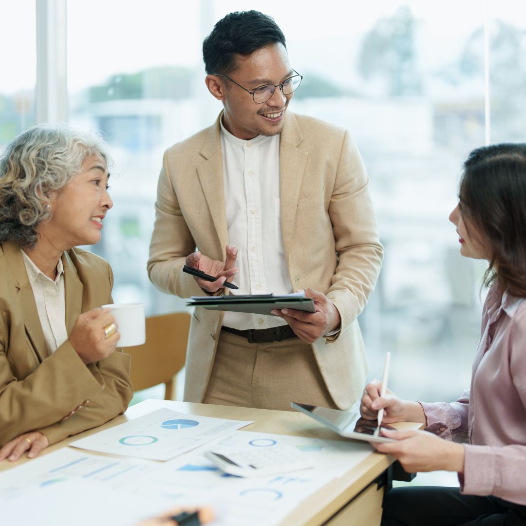 people looking at paperwork and tablets together